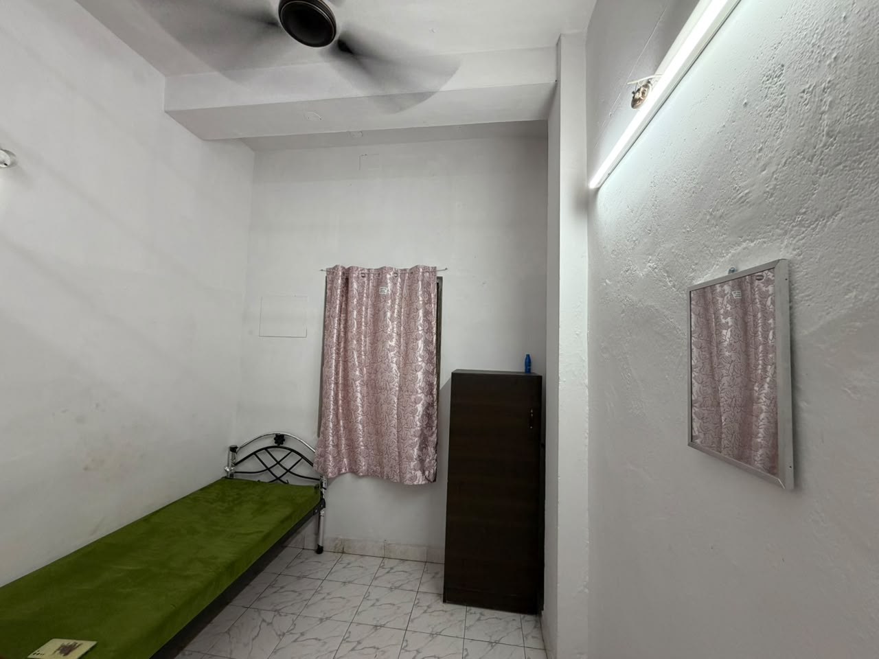 Single sharing room with a personal cot, wardrobe and mirror at Malarini Women's Hostel, West Mambalam